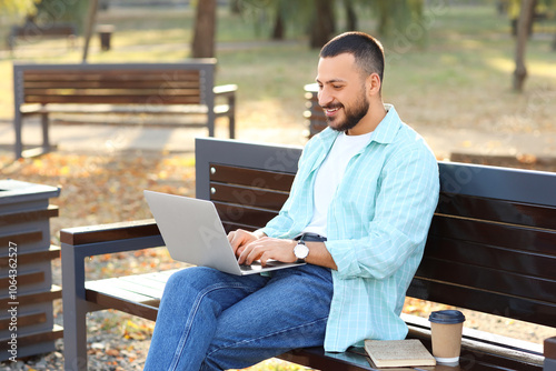 Young man using laptop on b...