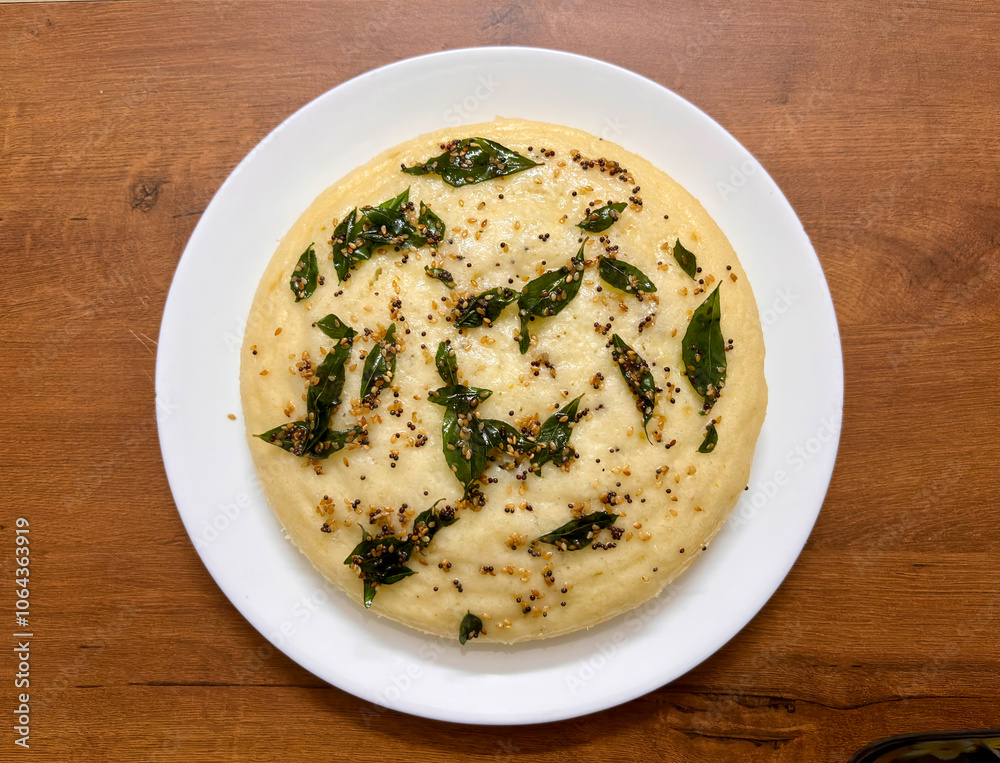 A plate of food (Indian Dhokla) with a green leaf on top