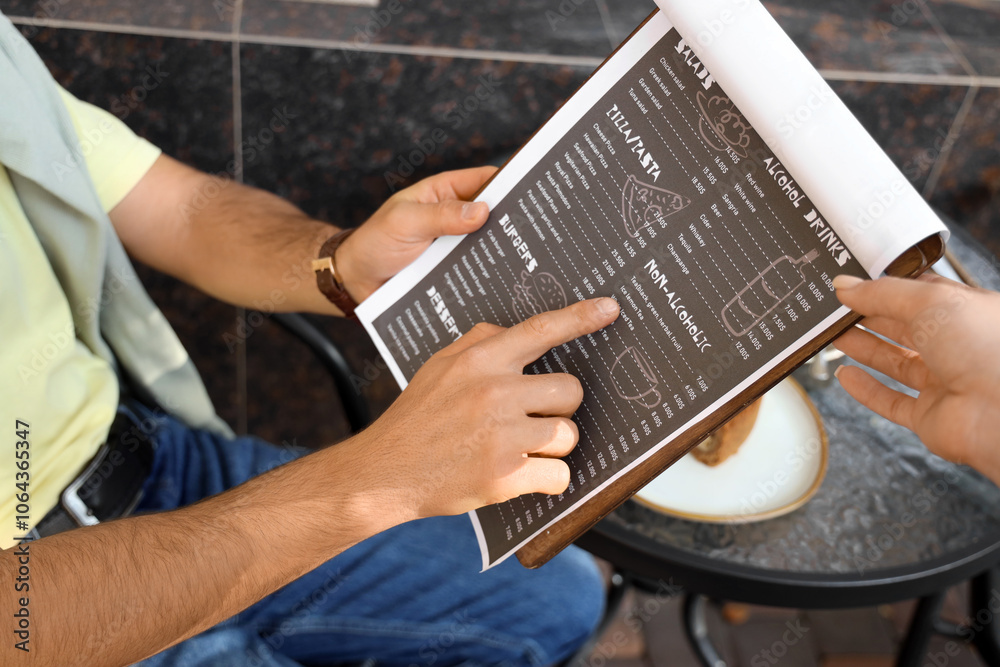 Fototapeta premium Young man with menu and waitress ordering drink in street cafe, closeup