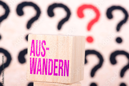 Konstfotografi Hintergrund aus vielen Fragezeichen und das Wort Auswandern