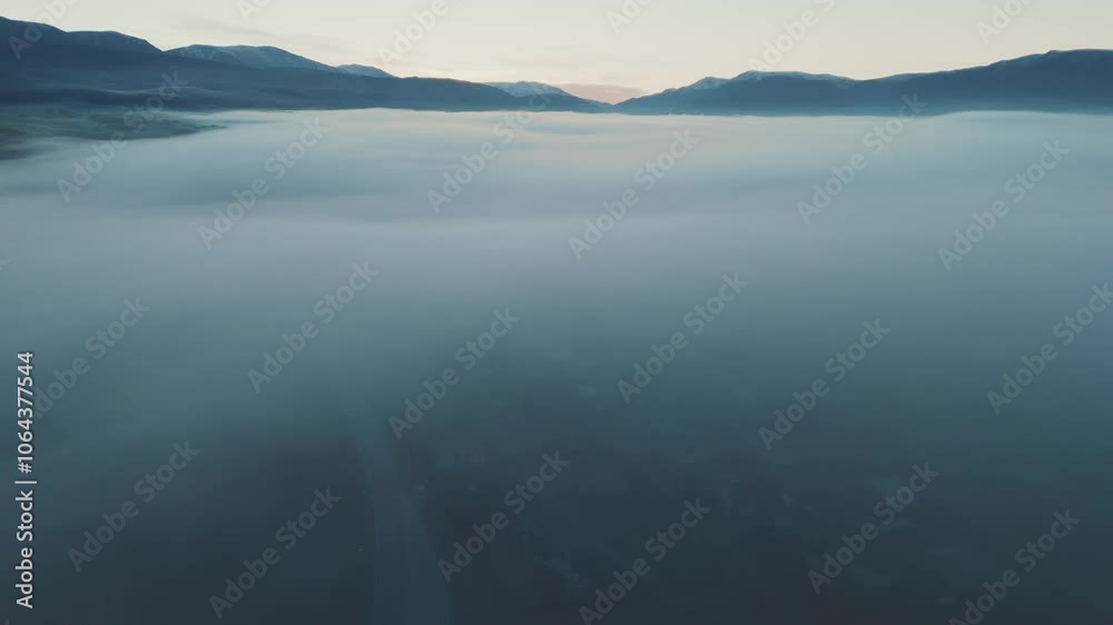 Morning fog envelops the valley as sunrise breaks over the mountains Morning fog envelops the valley as sunrise breaks over the mountains
