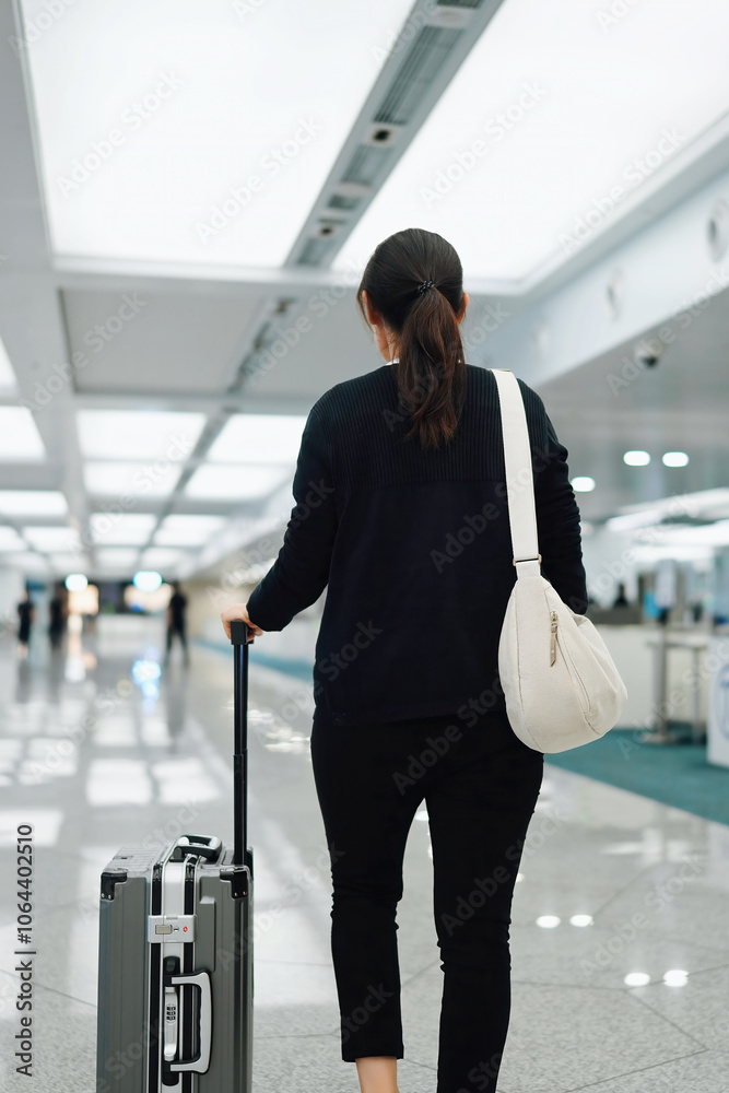 Fototapeta premium Journey Begins: Woman with Luggage in Modern Airport Terminal