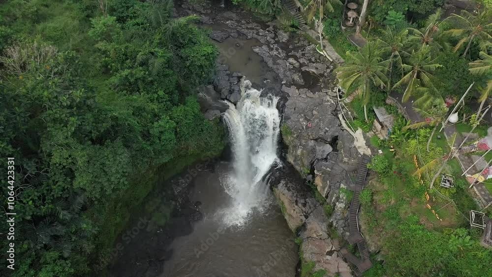 A beautiful landscape view with a waterfall flowing downstream through the forest in Tegenungan Waterfall, Bali, Indonesia A beautiful landscape view with a waterfall flowing downstream through the forest in Tegenungan Waterfall, Bali, Indonesia