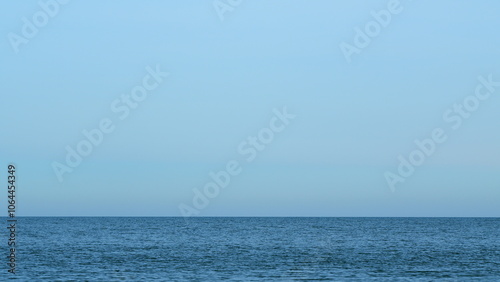 Quiet Seascape. Calming Waves Of The Sea Or Ocean During A Warm Sunny Day With A Blue Cloudless Sky. Still. photo