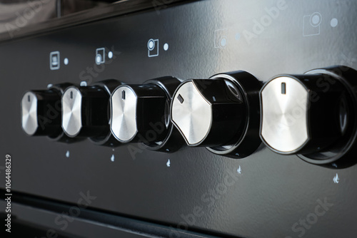 Close-up of a gas stove control panel knob with handle turned on in a home kitchen. photo