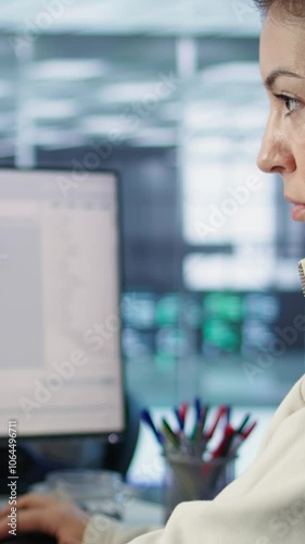 Smiling IT engineer in data center using PC to find misconfigurations affecting rackmounts. Cheerful woman checking servers bottlenecks leading to sluggish data transfer rates, camera B close up photo