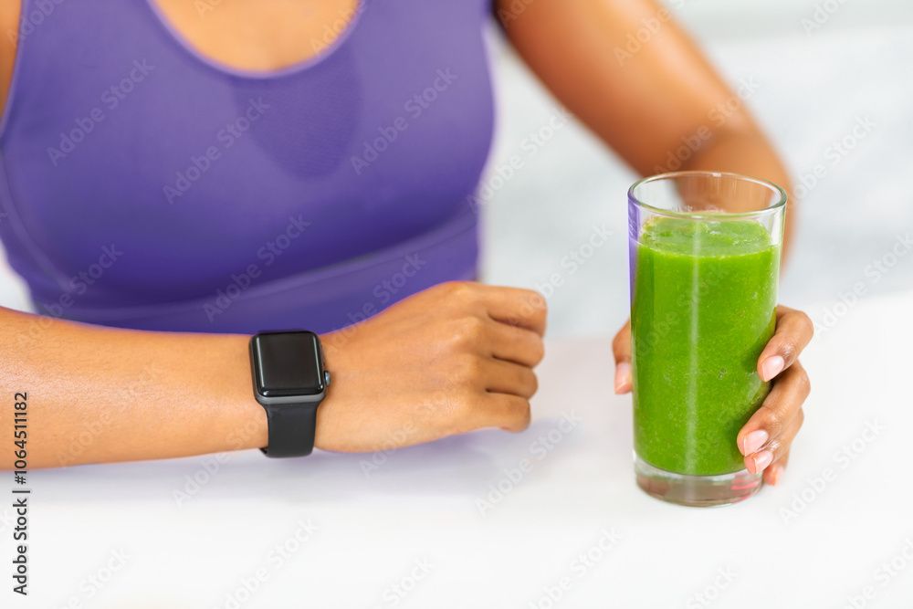 Healthy Lifestyle. Close up of unrecognizable black girl in red sports bra wearing smart watch and holding smoothie glass Healthy Lifestyle. Close up of unrecognizable black girl in red sports bra wearing smart watch and holding smoothie glass
