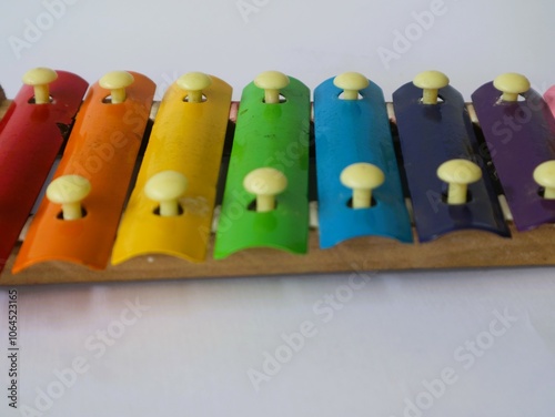 A xylophone is a percussion instrument consisting of a series of wooden or metal bars arranged in ascending pitch that are struck with mallets to produce clear, bright tones, isolated white.  photo