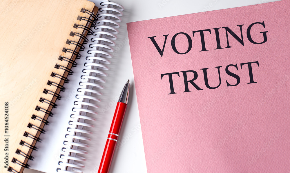 Voting trust concept with pink document, notebooks, and red pen on a white surface Voting trust concept with pink document, notebooks, and red pen on a white surface