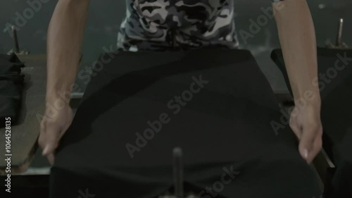 preparing t-shirt for printing. man holding black shirt an put it on the printing table