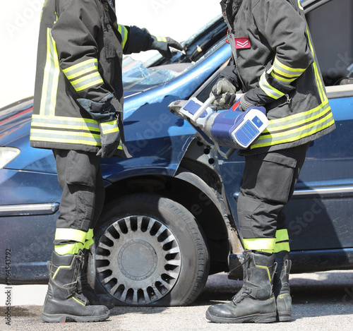 firefighters using powerful hydraulic shears to cut through the car to free the injured person