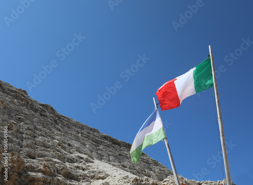 Italian flag and flag of Ladinia the Alpine region in the Dolomites Area of Northern Italy and the rocks of Mountain photo