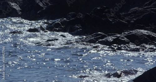 waves crashing over dark black rocks at east Tarbet beach, mull of Galloway