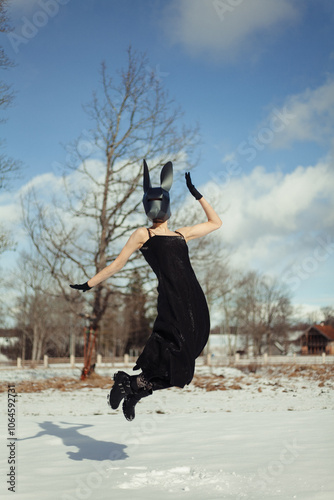 Jumping Woman in Black Dress with Rabbit Mask