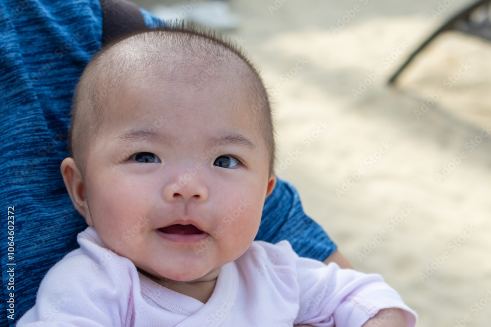 Smiling asian baby looking happy being held by parent Smiling asian baby looking happy being held by parent