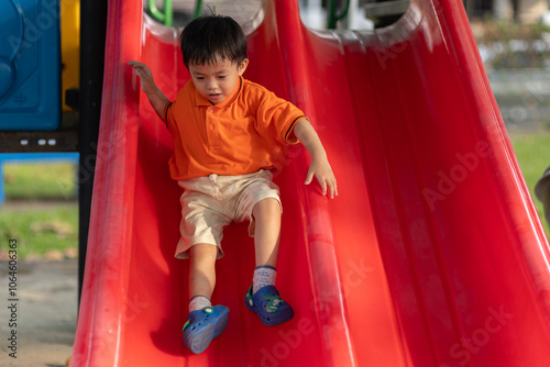 Happy young Asian boy enjoys playing at outdoor park #1064606363