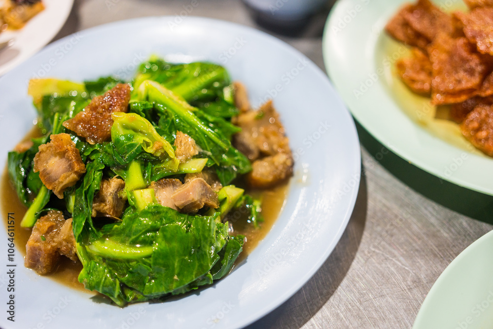 Stir fried baby cabbage with crispy pork on dish Stir fried baby cabbage with crispy pork on dish