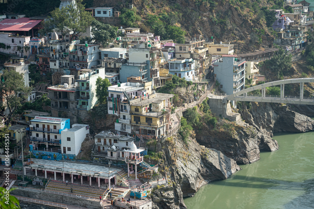 Obraz premium Sangam place of Alakhnanda and Bhagirathi River in Devprayag, Uttarakand. The surrounding building, man made structure, mountains make this place a must visit destination