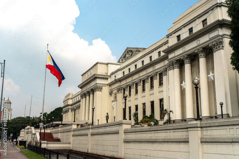 Fototapeta premium The exterior of the National Museum of Philippine Fine Arts in Manila, Philippines, with the Philippine flag.