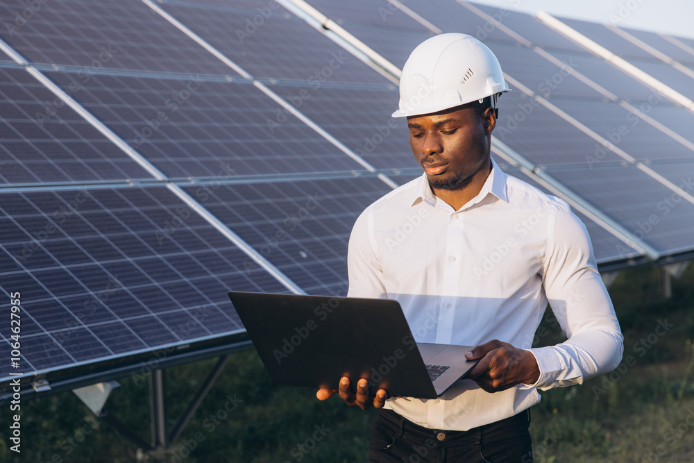 African American Engineer Working on Laptop Near Solar Panels Outdoors African American Engineer Working on Laptop Near Solar Panels Outdoors