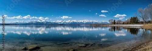 Tranquil Winter Wonderland: Snow-Capped Mountains Reflected in Serene Lake