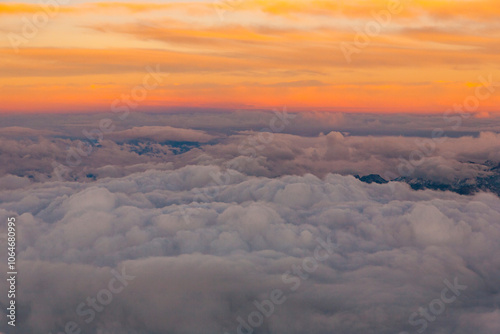 View through an aircraft window of sunset above clouds photo