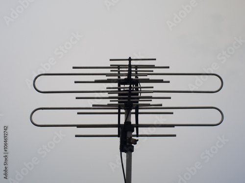 Television antenna with cloudy sky background.