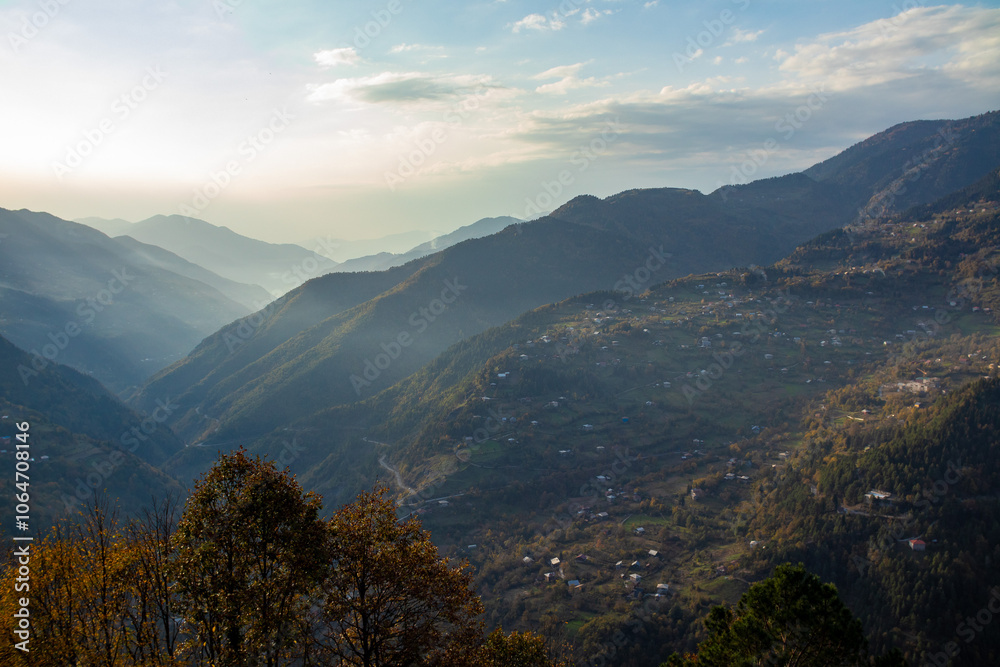 Fototapeta premium A stunning view of a valley surrounded by tall mountains and trees