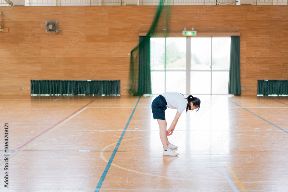 Obraz premium 体育館でストレッチをする女の子