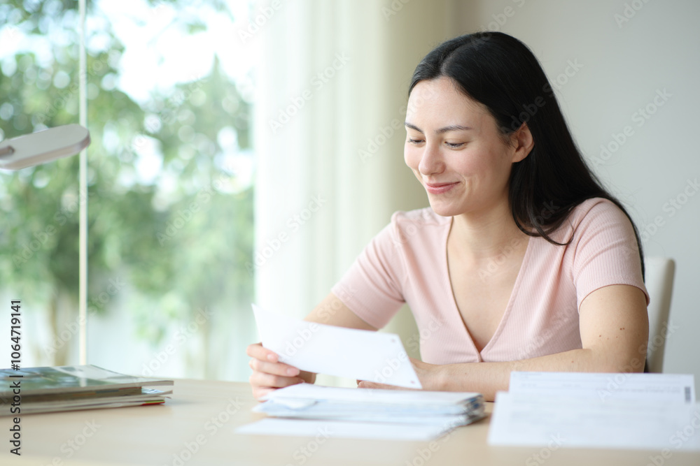 Asian woman checking receipt at home Asian woman checking receipt at home