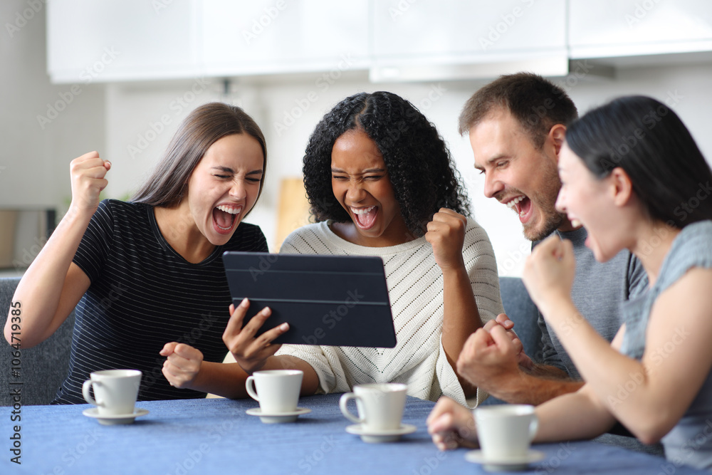 Four excited interracial friends watching media on tablet Four excited interracial friends watching media on tablet