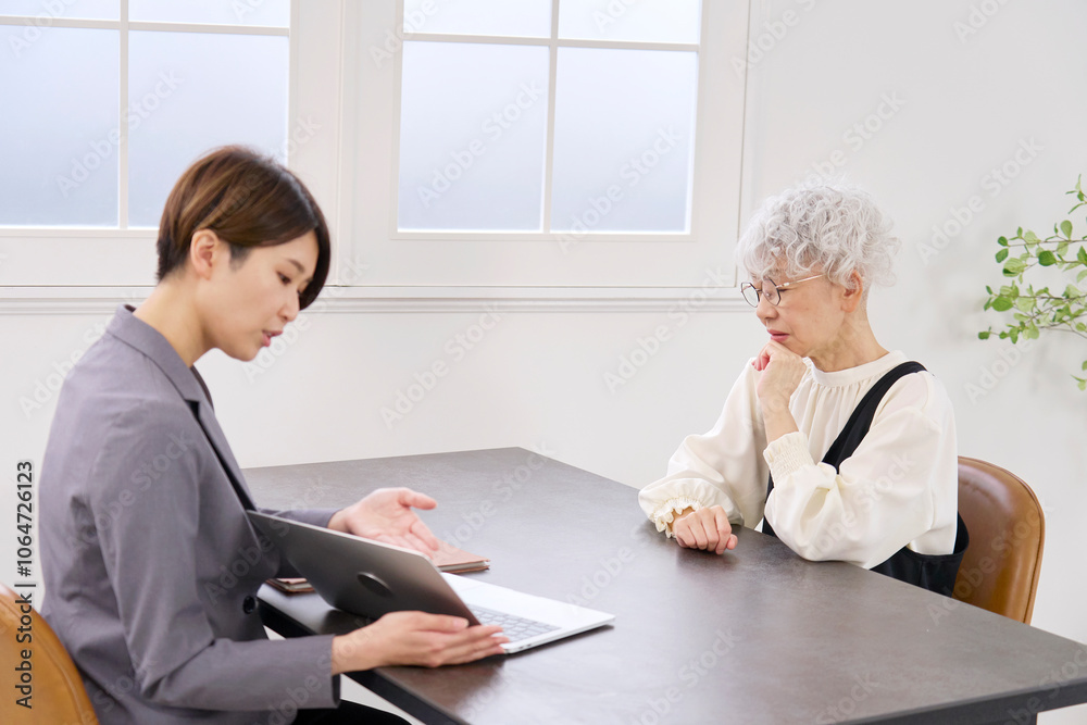 保険の営業で悩む高齢者の女性 保険の営業で悩む高齢者の女性