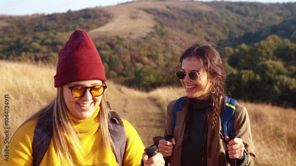 Two smiling woman hiking at top of the hill at meadow. Two smiling woman hiking at top of the hill at meadow.