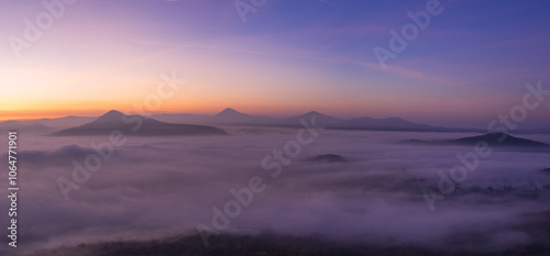 Hills in foggy evening. Radobyl hill in Czech Midland/ Ceske Stredohori, Czech republic