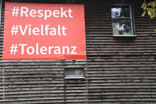 Plakat mit weißer Schrift auf rotem Hintergrund: Respekt - Vielfalt - Toleranz , auf Bretterhintergrund