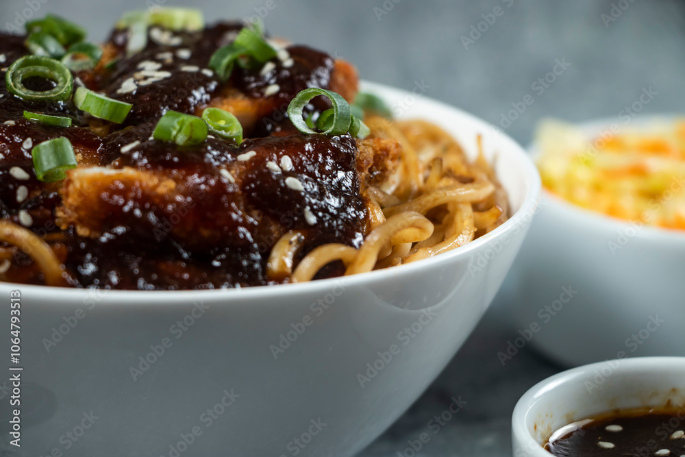 Spicy Teriyaki Fried Chicken Noodles with green onion, spicy sauce, cabbage salad and fork served in bowl isolated on grey background side view of japanese food Spicy Teriyaki Fried Chicken Noodles with green onion, spicy sauce, cabbage salad and fork served in bowl isolated on grey background side view of japanese food