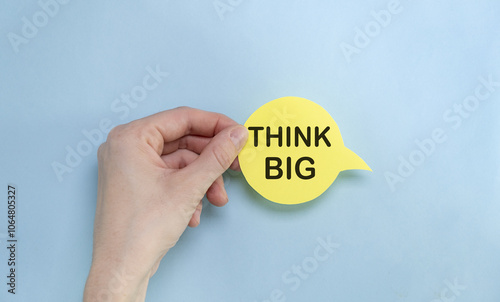 the yellow stacking of white business card with Think Big message on vibrant blue background