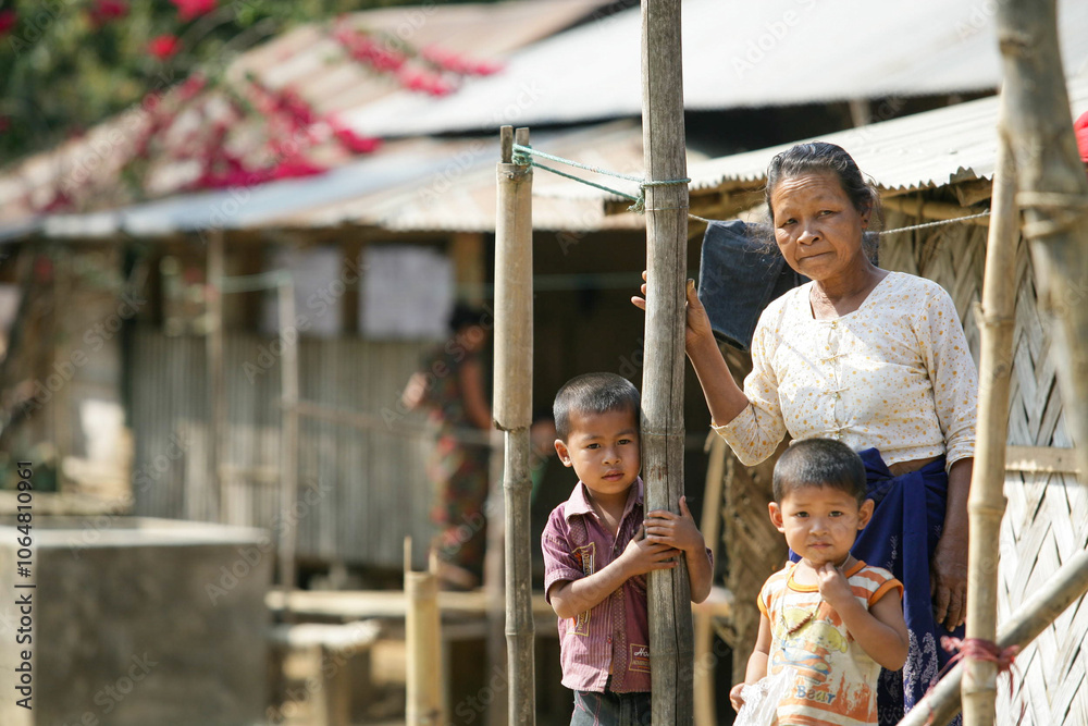 Obraz premium Bangladeshi tribal grandmother standing with her grandchildren 