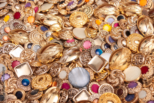 Top down view of large number of luxurious, golden clothing buttons.