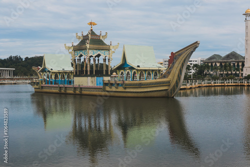 A Bruneian boat with intricate designs rests peacefully in calm waters photo