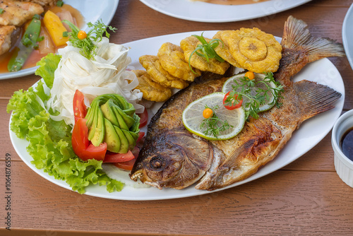 Pescado ahumado con patacones y ensalada fresca de chonta, palta y tomate photo