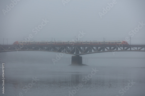 The SKM (Fast Urban Railway) train crossing the Vistula River on the Średnicowy rail bridge in Warsaw on a magically foggy October day.