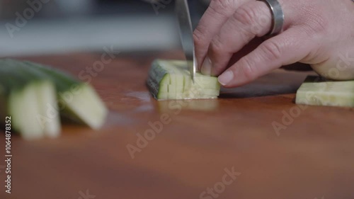 Close-up shot of a chef slicing cucumbers into tiny squares, showcasing precision and technique. Perfect for cooking tutorials, food preparation, and culinary presentations. photo