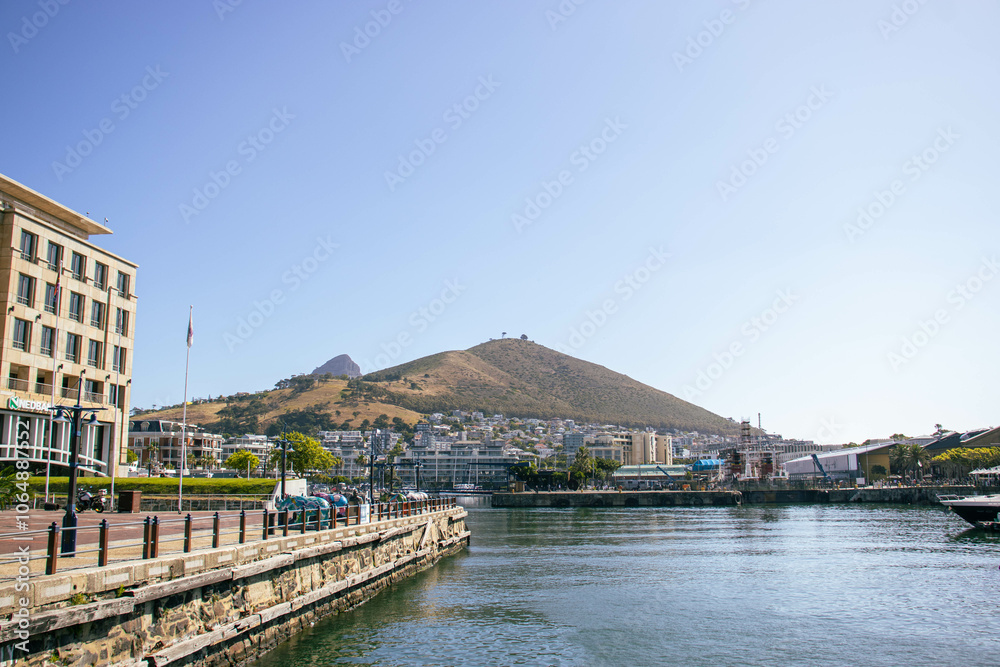 Fototapeta premium A view of a vibrant city neighborhood with hills behind it ona clear sky summer day