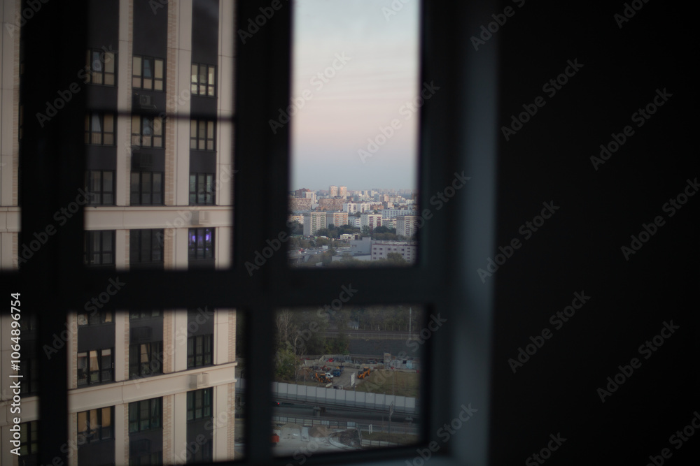 Obraz premium City view through window with soft evening light, urban skyline and minimal interior concept