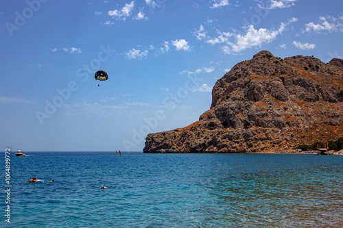 Parasailing tourists on the island of Rhodes with views of mount Tsambika, Greece photo