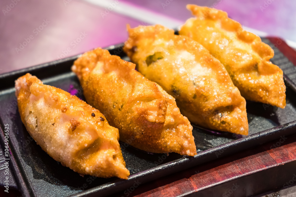 Crispy Golden Fried Dumplings Served on Elegant Black Plate - Authentic Asian Cuisine Crispy Golden Fried Dumplings Served on Elegant Black Plate - Authentic Asian Cuisine