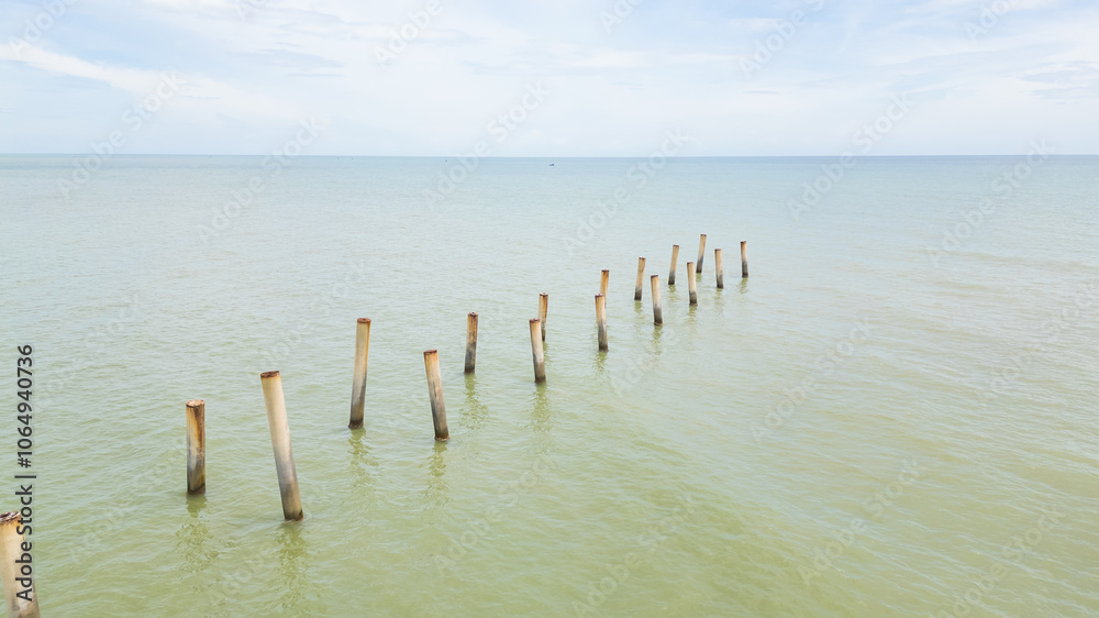 Fototapeta premium Beach Serenity.Old Posts and Calm Waters