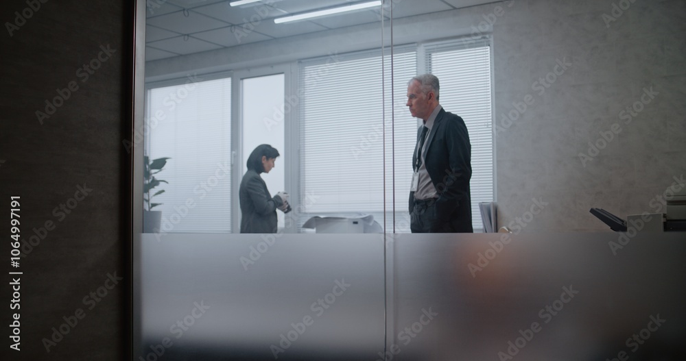 Fototapeta premium Office robbery case: Crime investigation team at crime scene. Female criminalist takes photos of clues and evidence, then talks to male detective. African American policeman searches fingerprints.