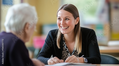A social worker is smiling and actively listening to an elderly client, creating a supportive atmosphere during their counseling session
